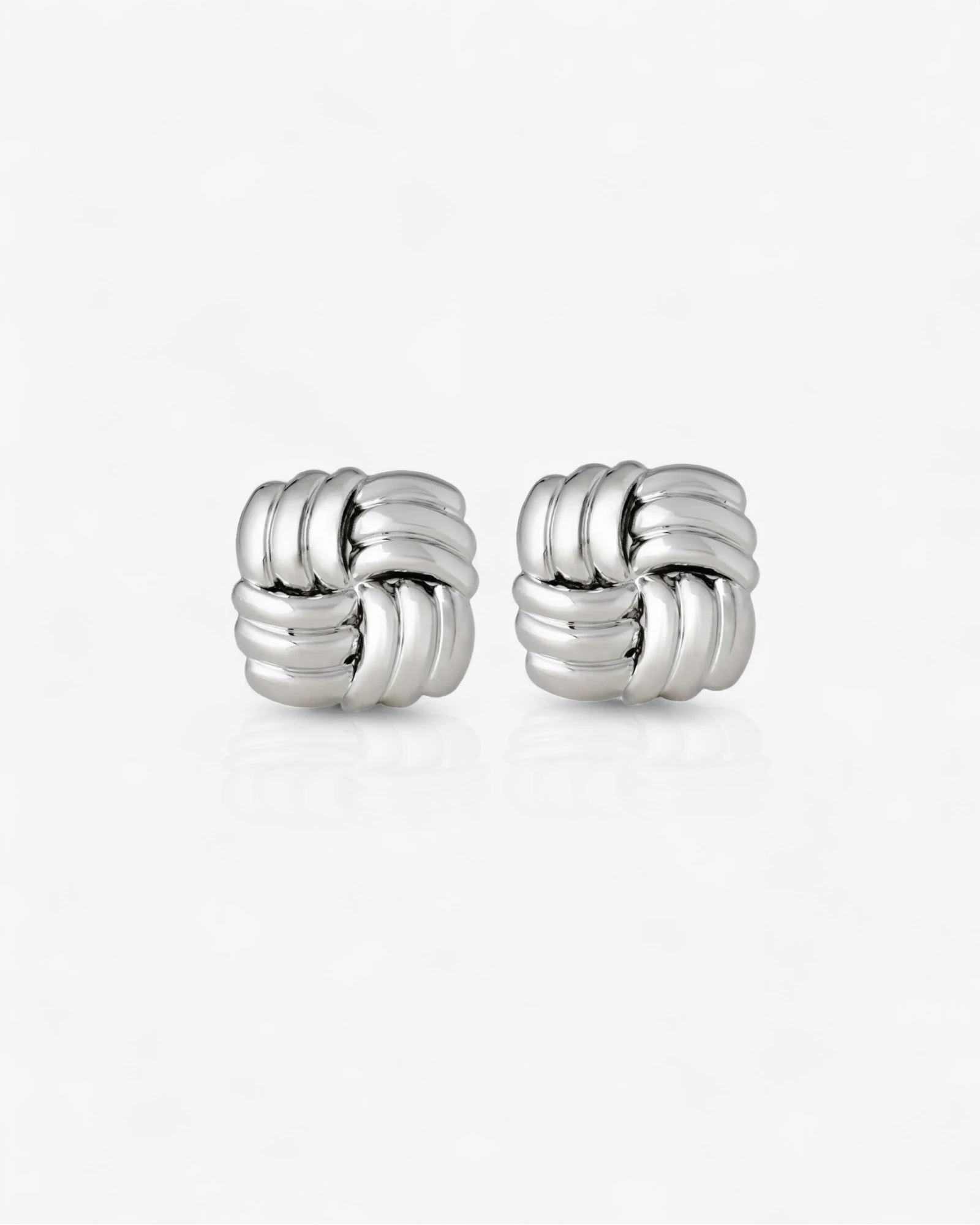Pair of silver knot earrings on a white background