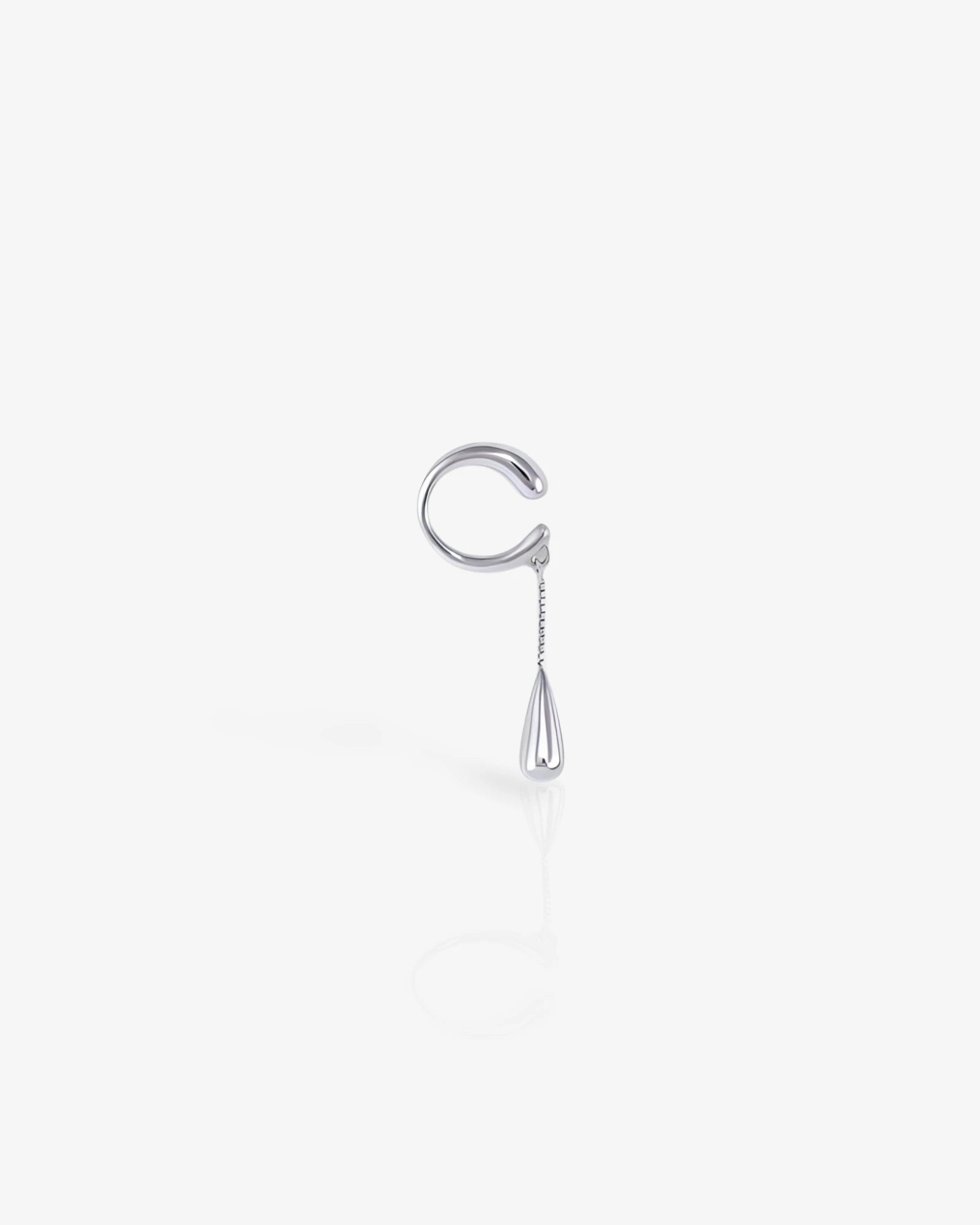 Silver earring with a dangling teardrop on a white background