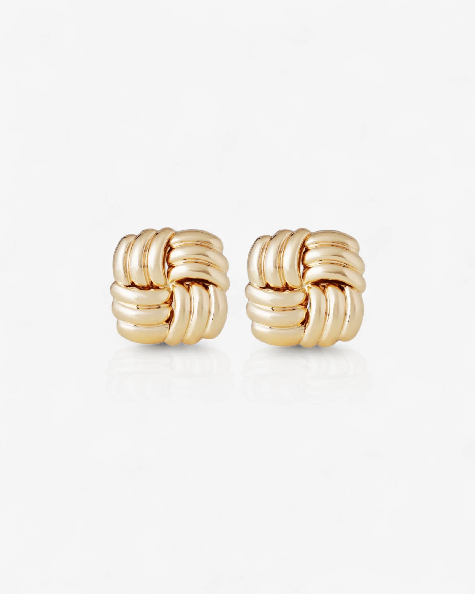 Pair of gold knot earrings on a white background