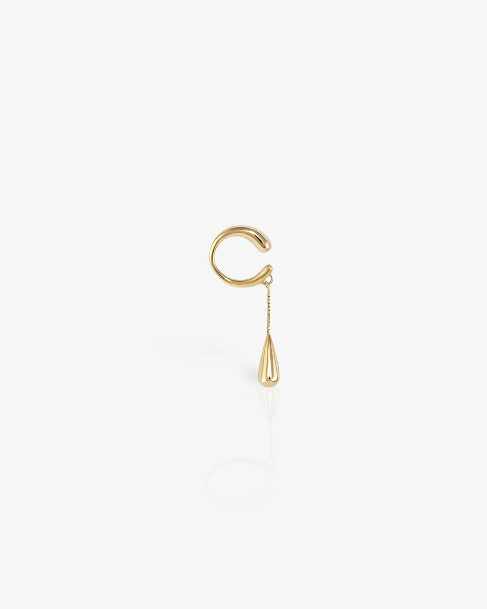 Gold ear cuff with a small chain on a white background